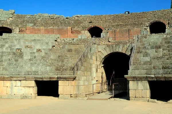 El muro del podio con los vanos abovedados de acceso a la arena